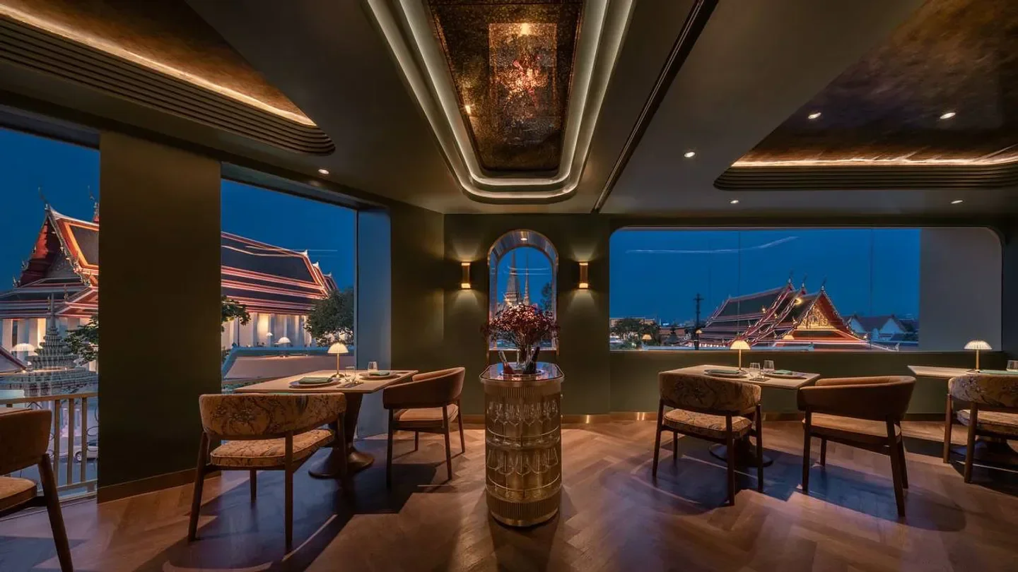 Interior of Nusara restaurant in Bangkok, featuring views of a temple at night