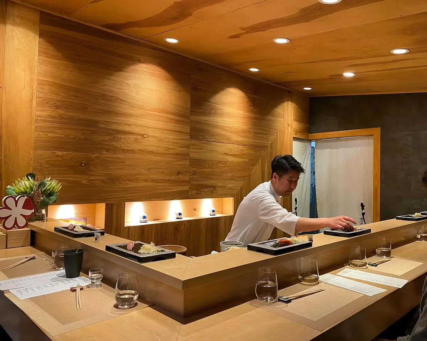Chef preparing sushi at Omakase Yume restaurant in Chicago, wooden interior