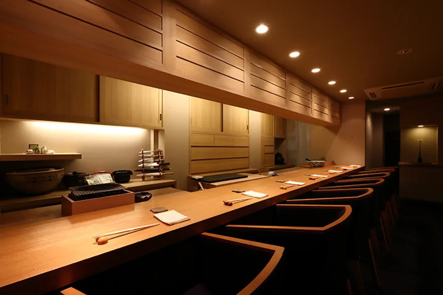 Interior of Onarimon Haru restaurant in Tokyo, featuring a sushi bar and wooden decor.