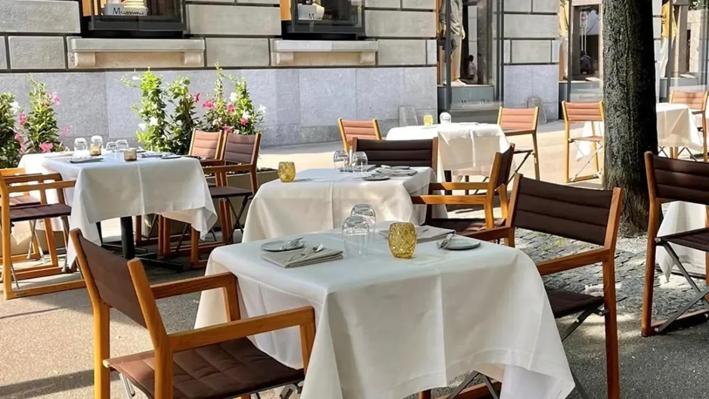 Outdoor seating at Ornellaia restaurant in Zurich, set tables with white tablecloths.