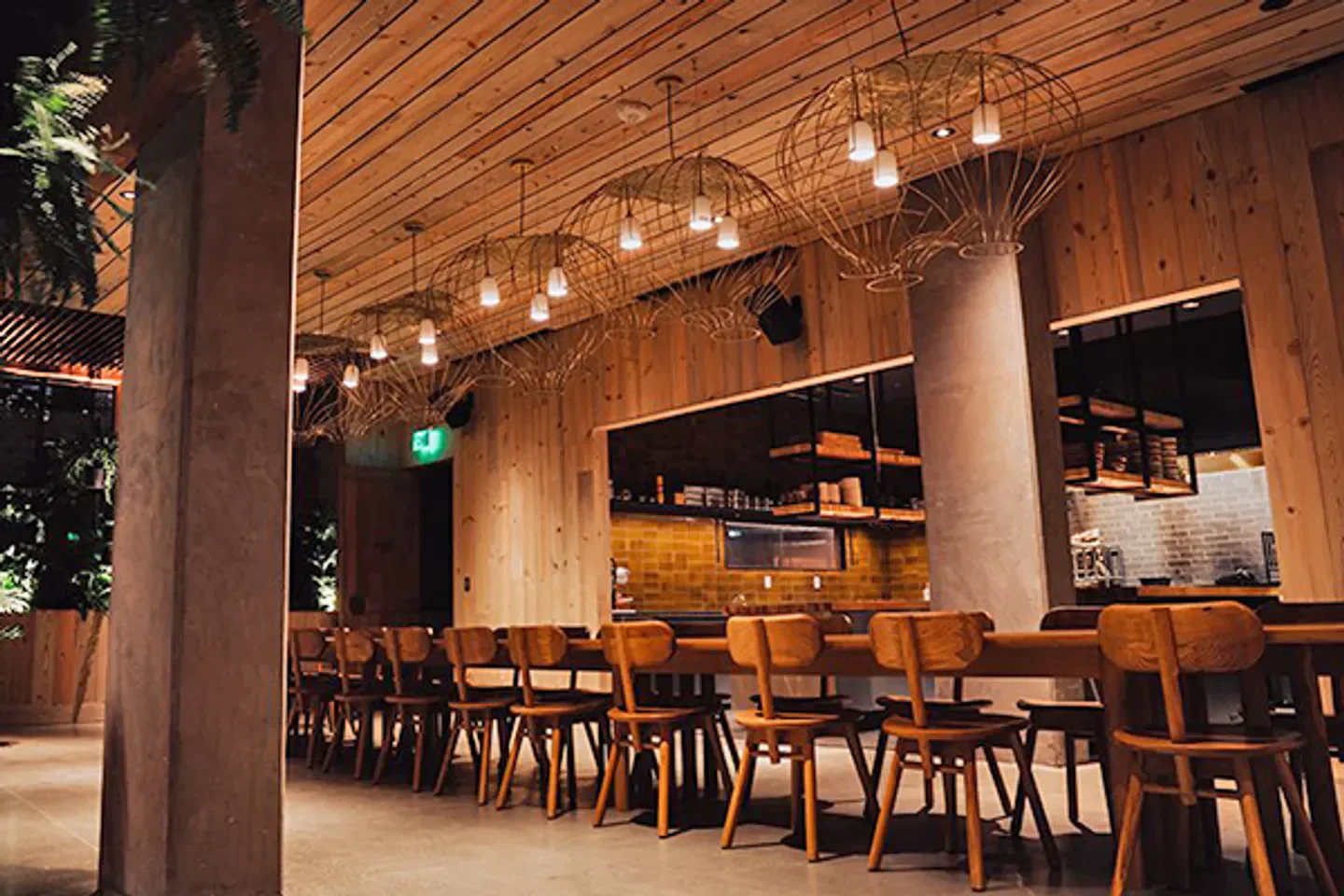 Interior of Osito restaurant in San Francisco with wooden tables and light fixtures.