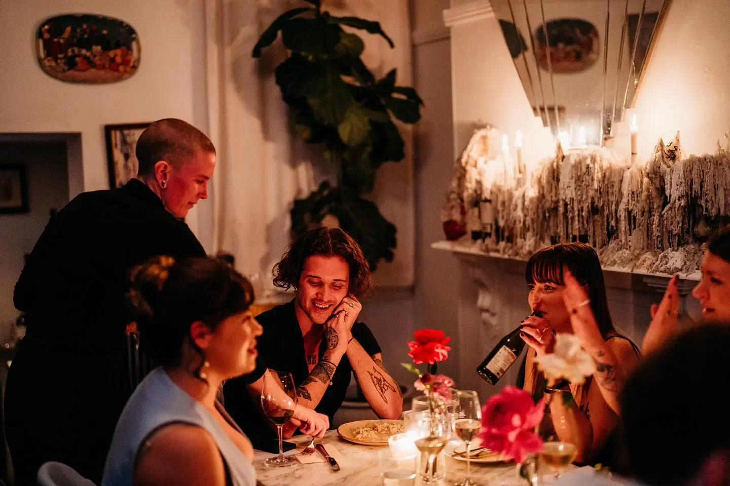 Cozy dining scene at Osteria di Russo & Russo in Sydney, featuring friends and candlelight.