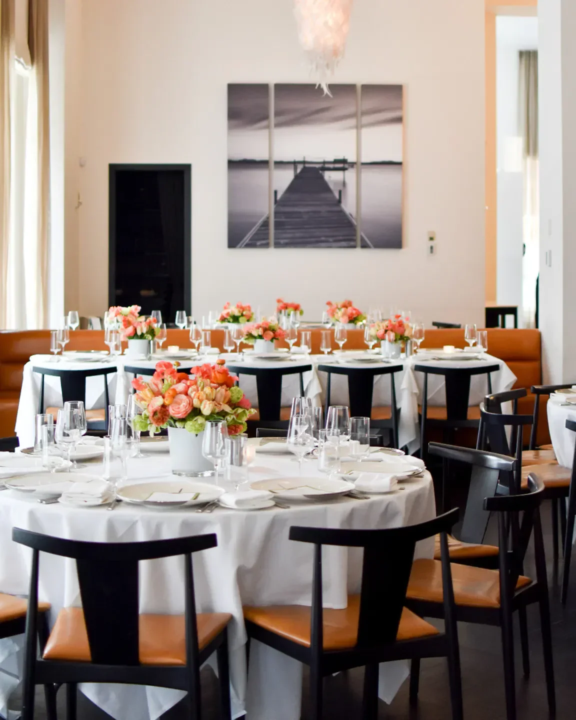 Elegant dining room at Ostra restaurant in Boston, with tables set for service.