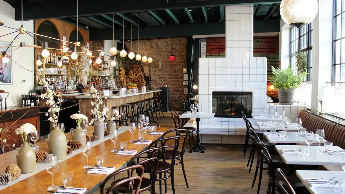 Interior of Pammy's restaurant in Boston, featuring bar, tables, fireplace, and decor.