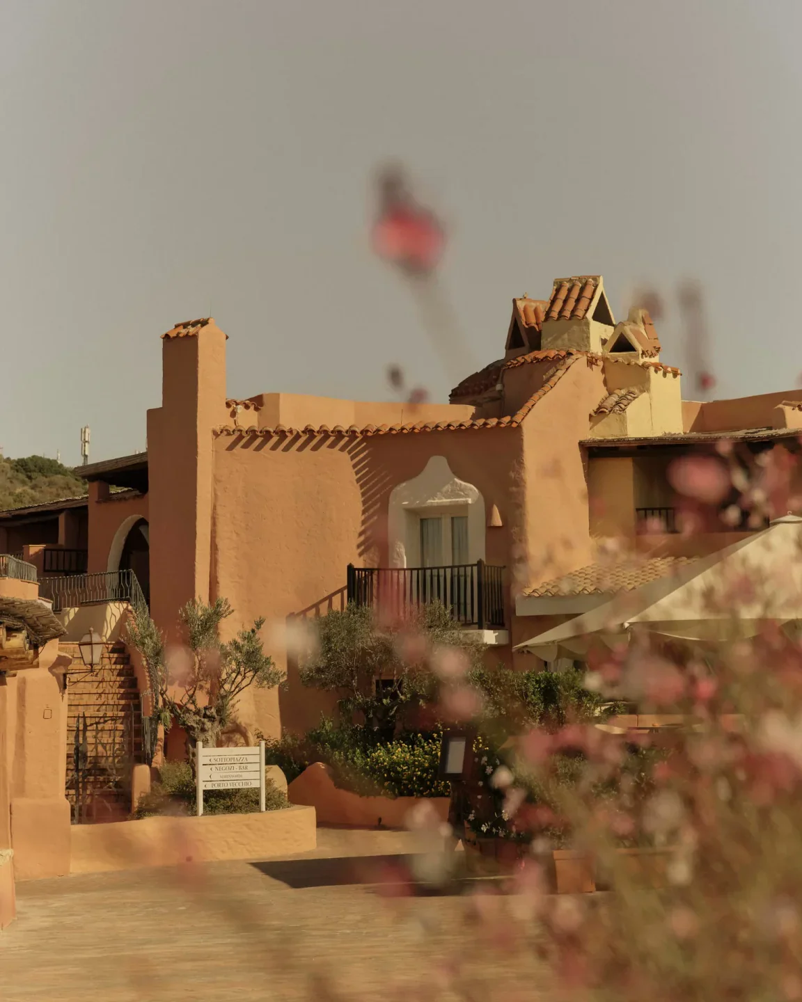 Exterior of Paper Moon restaurant in Porto Cervo with terracotta accents and lush greenery
