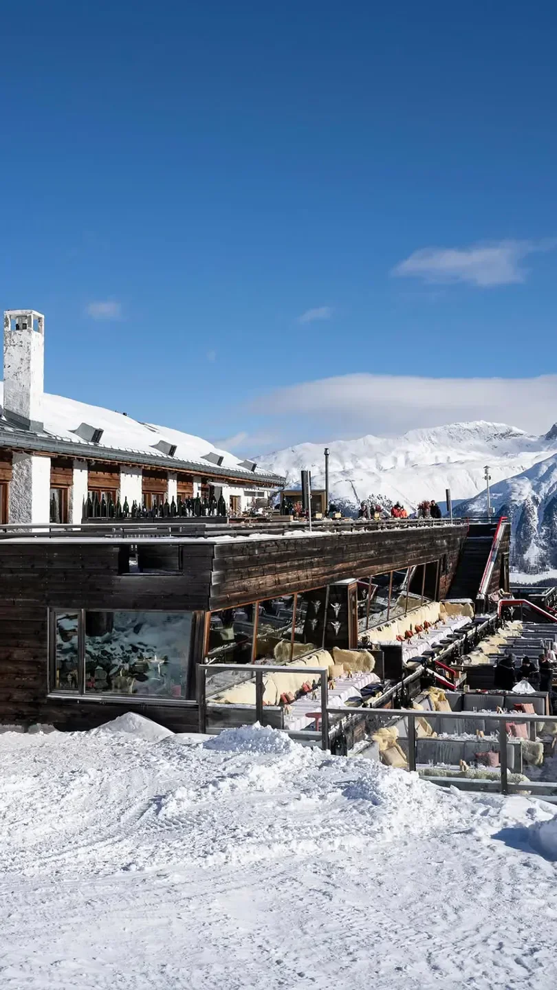 Outdoor dining at Paradiso Mountain Club & Restaurant in St. Moritz with snowy mountain views