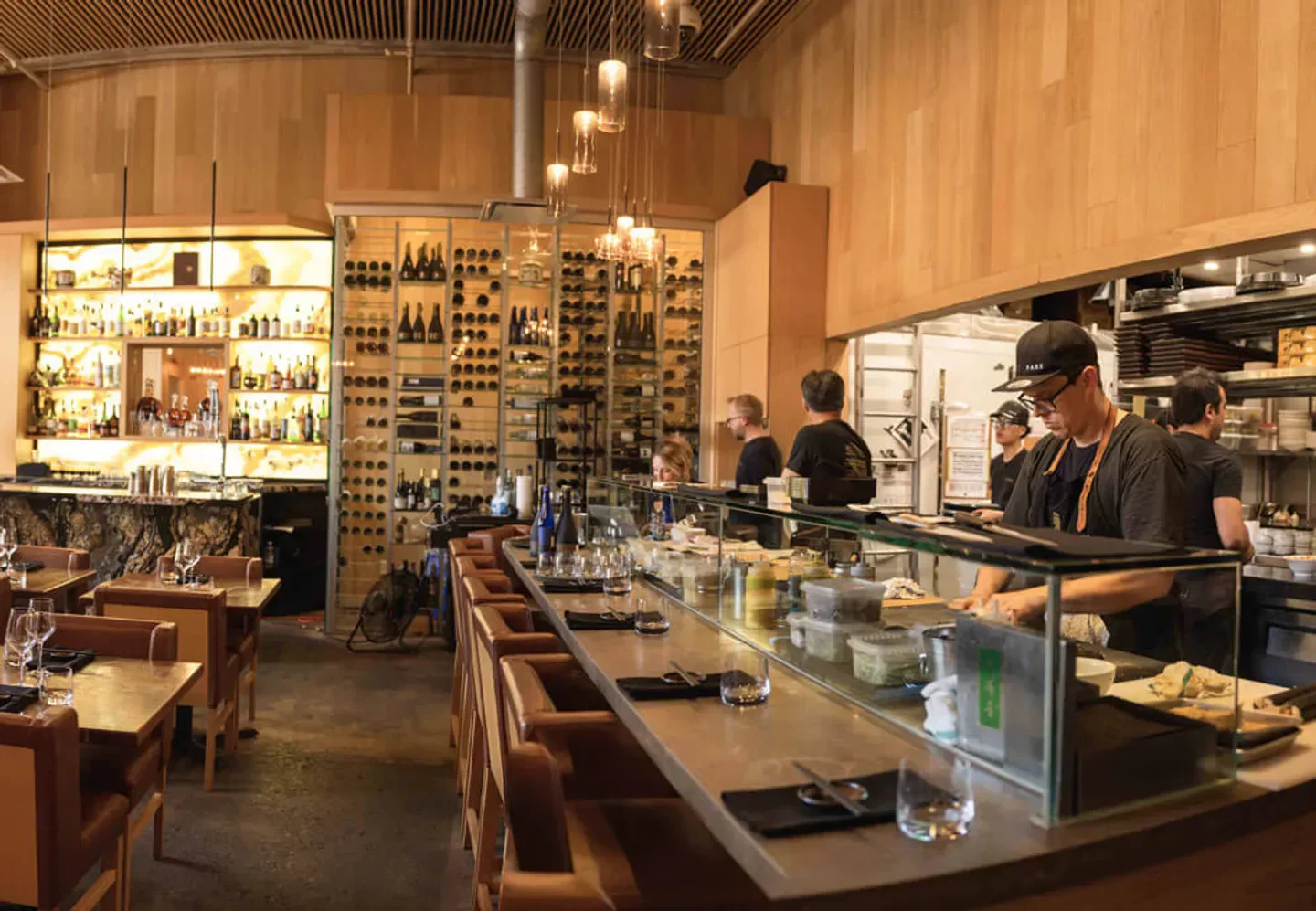 Interior of PARK Montreal restaurant with bar, open kitchen, and dining area.