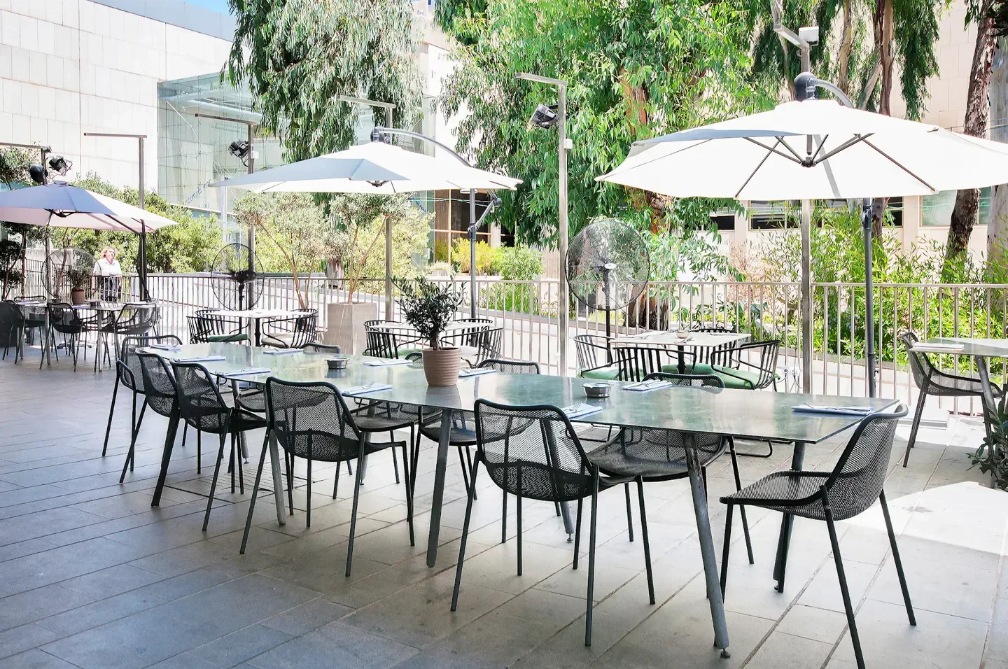 Outdoor seating at Pastel restaurant in Tel Aviv, with umbrellas and a modern aesthetic.