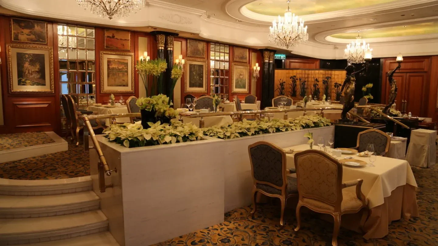 Elegant interior of Petrus restaurant in Hong Kong, with chandeliers and dining tables.