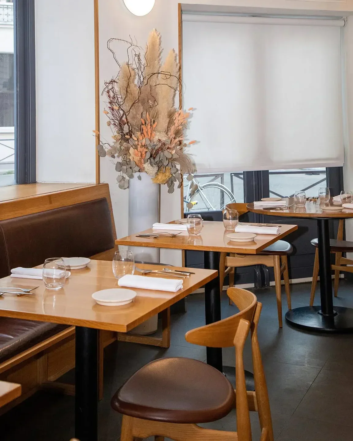 Interior of Pilgrim restaurant in Paris, featuring tables, chairs, and decorative floral arrangement.