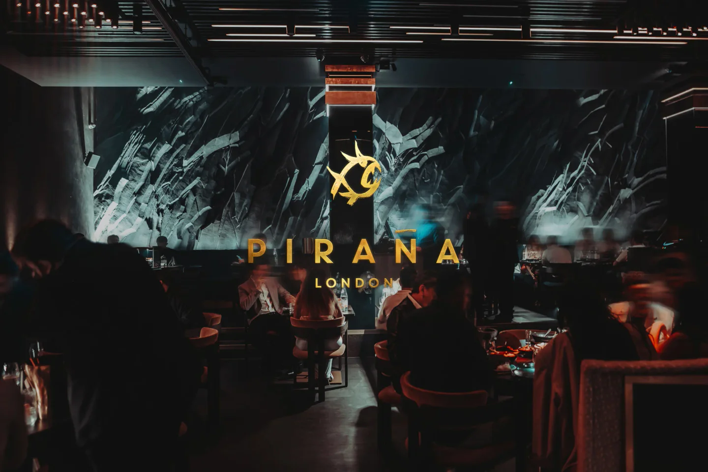 PIRANA London restaurant interior featuring a dramatic textured wall and ambient dining atmosphere.