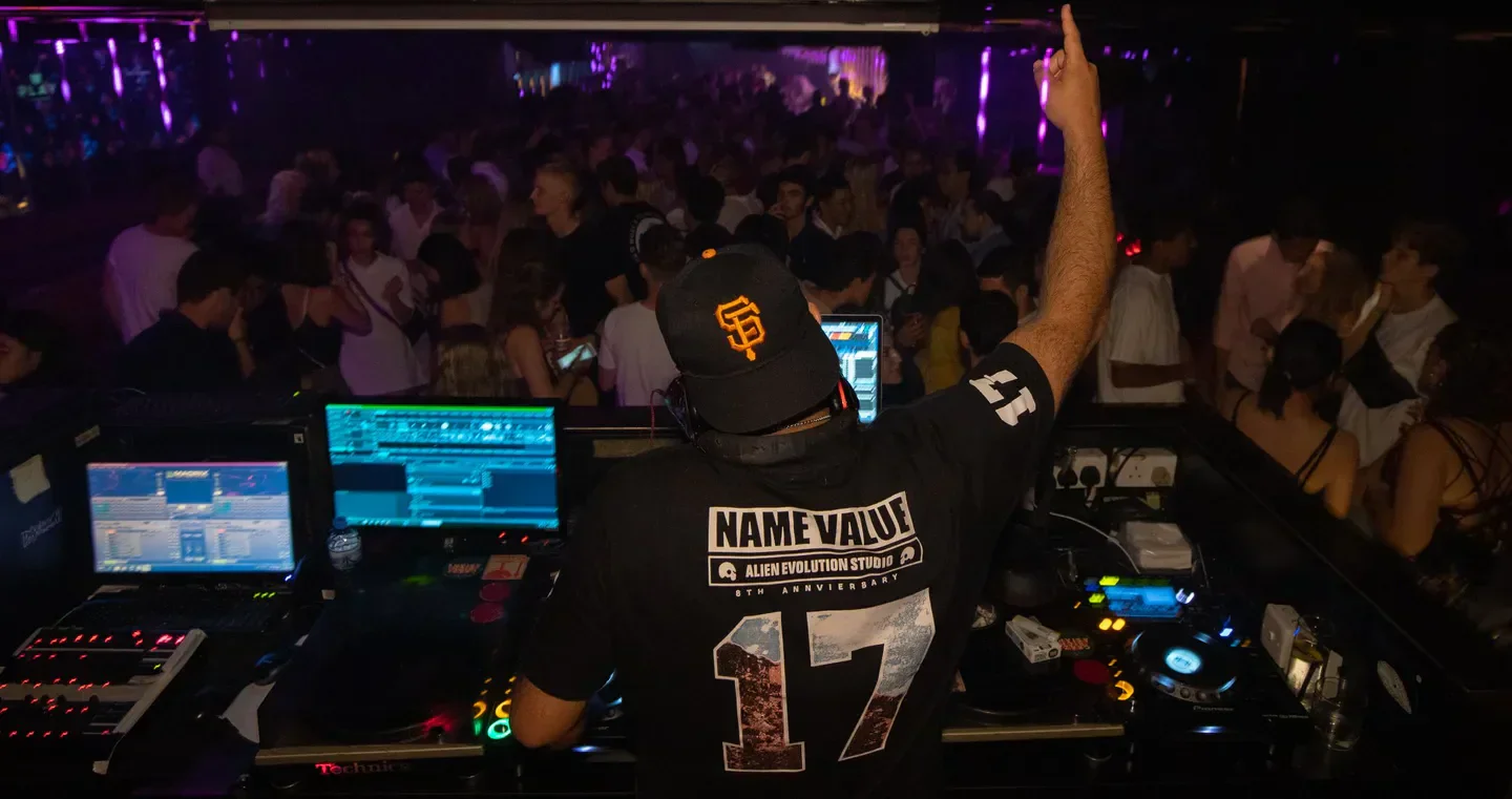 DJ at Play nightclub in Hong Kong, pointing to the crowd during a lively party.