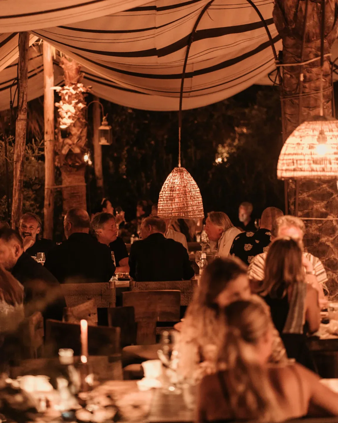 Evening ambiance at Playa Soleil Ibiza featuring warm lighting, canopy, and diners enjoying a meal.