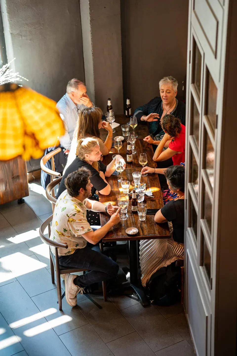 Group of friends dining at Porkfat restaurant in Sydney, enjoying food and drinks.