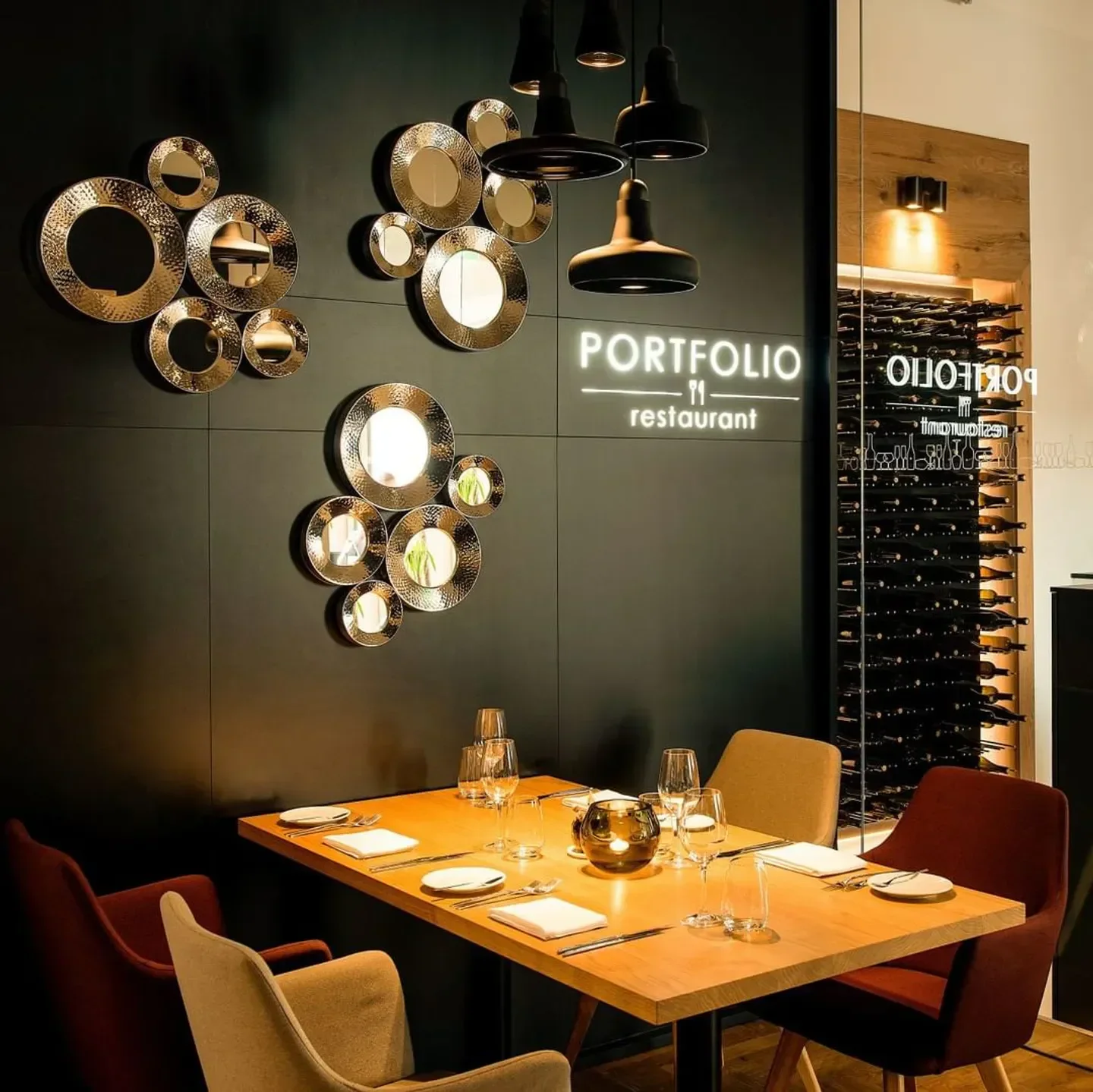 Stylish interior of Portfolio restaurant in Prague featuring decorative mirrors and a dining table.