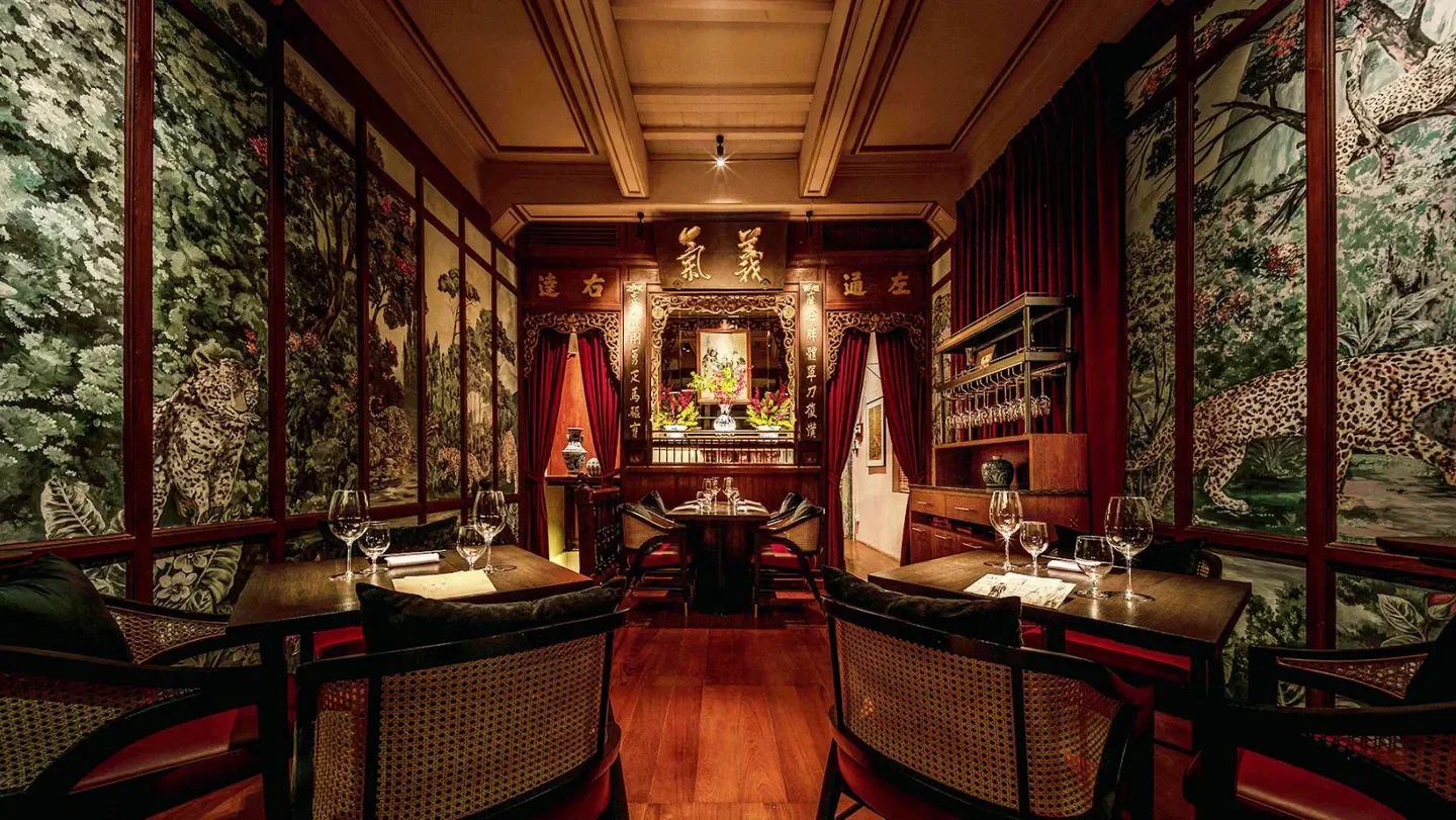 Interior of POTONG restaurant in Bangkok, featuring luxurious decor with leopard wallpaper.