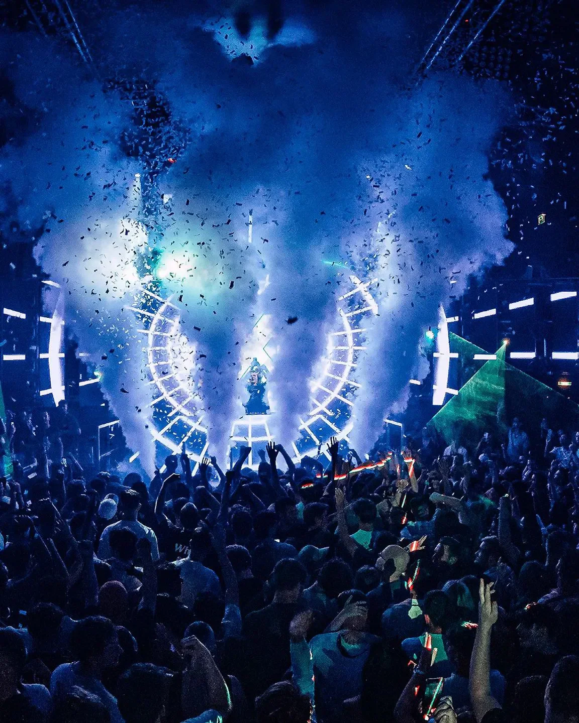 Energetic crowd at Prater Dome nightclub in Vienna with confetti and light show.