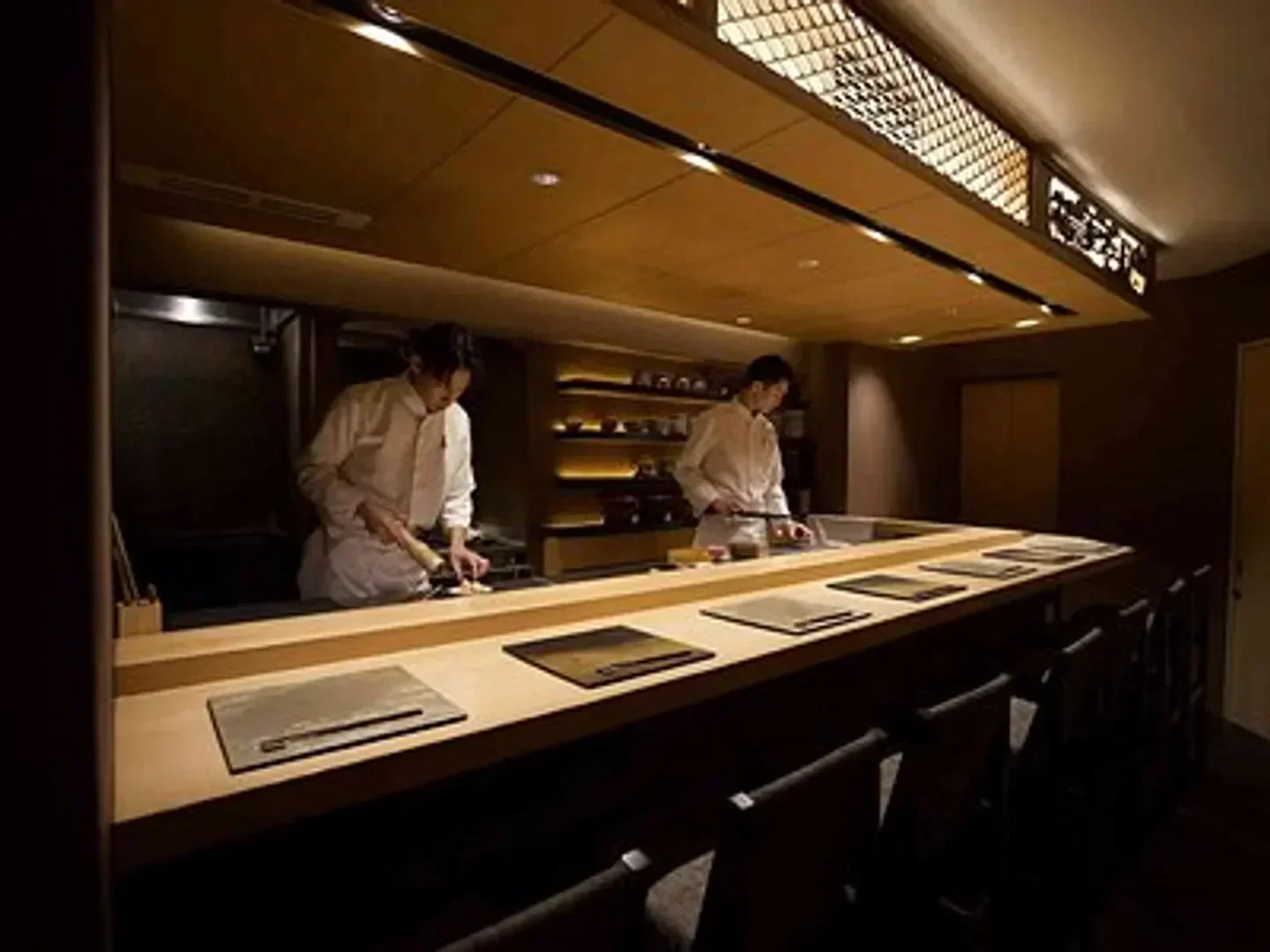 Chefs preparing food at Principio restaurant in Tokyo, showcasing elegant interior design