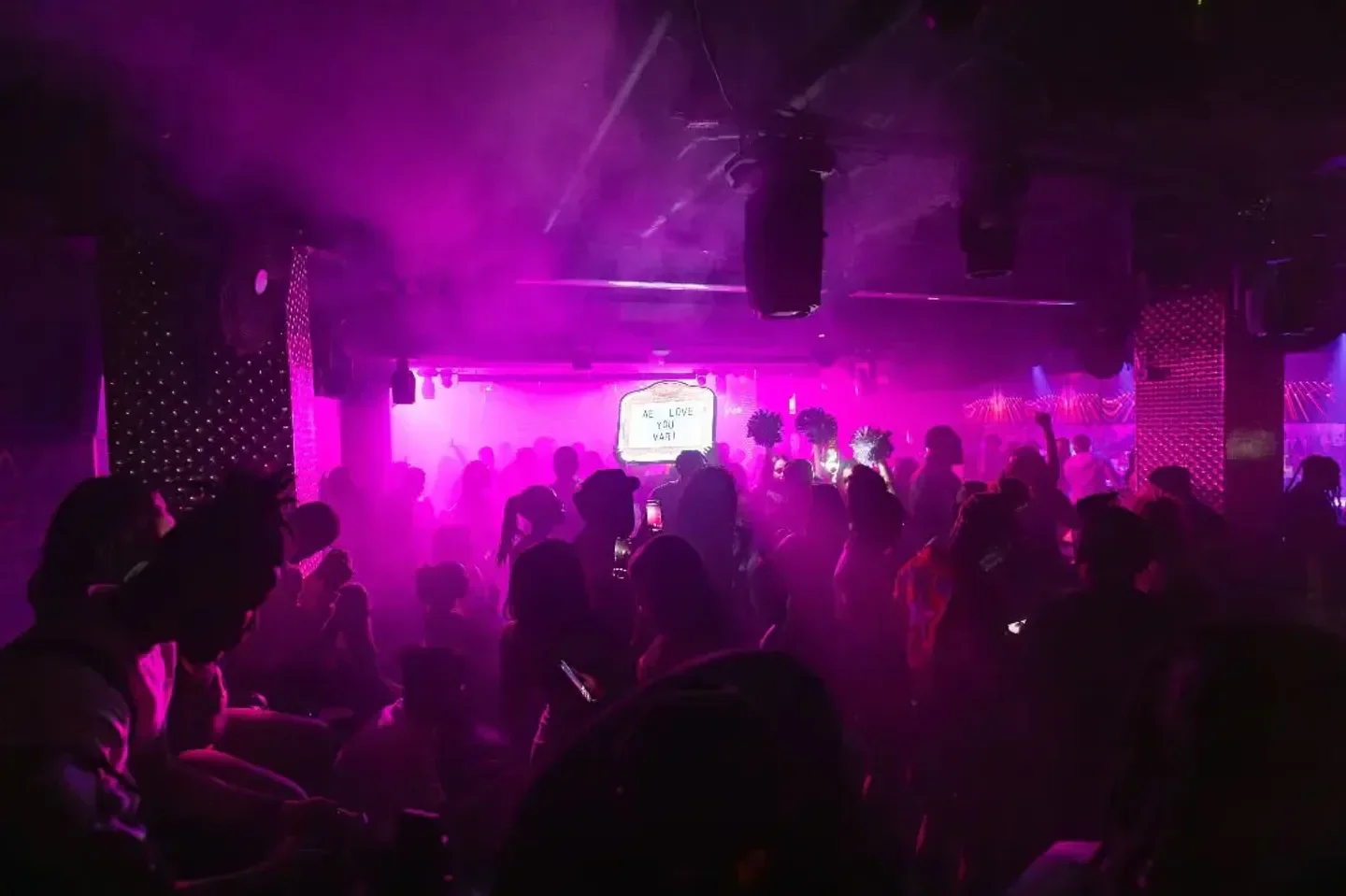 Energetic crowd at Privilege DC Nightclub & Lounge in Washington, glowing in purple lights.