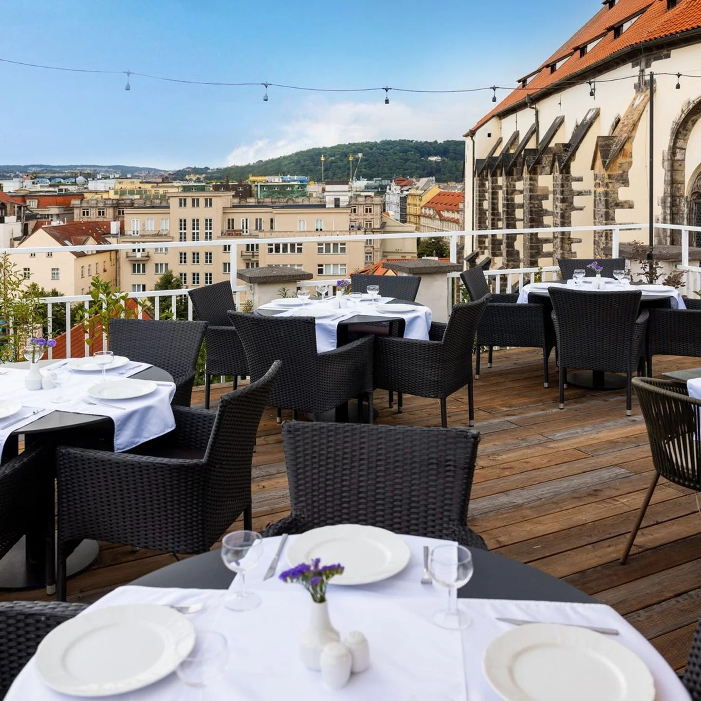 Rooftop dining at Pytloun Sky Bar in Prague with elegant table settings and panoramic city views.