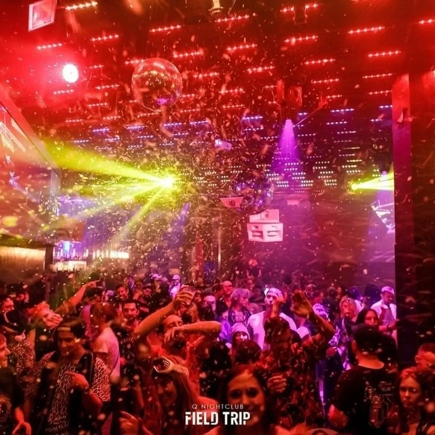 Energetic crowd at Q Nightclub in Seattle with confetti and disco ball.