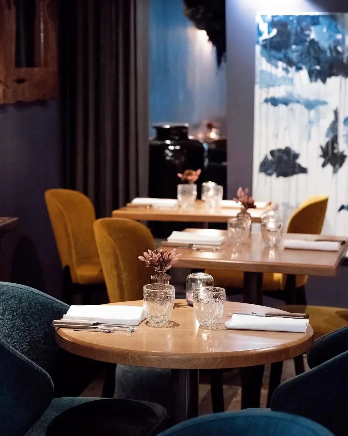Cozy dining room at Qui plume la Lune in Paris with elegant table settings.