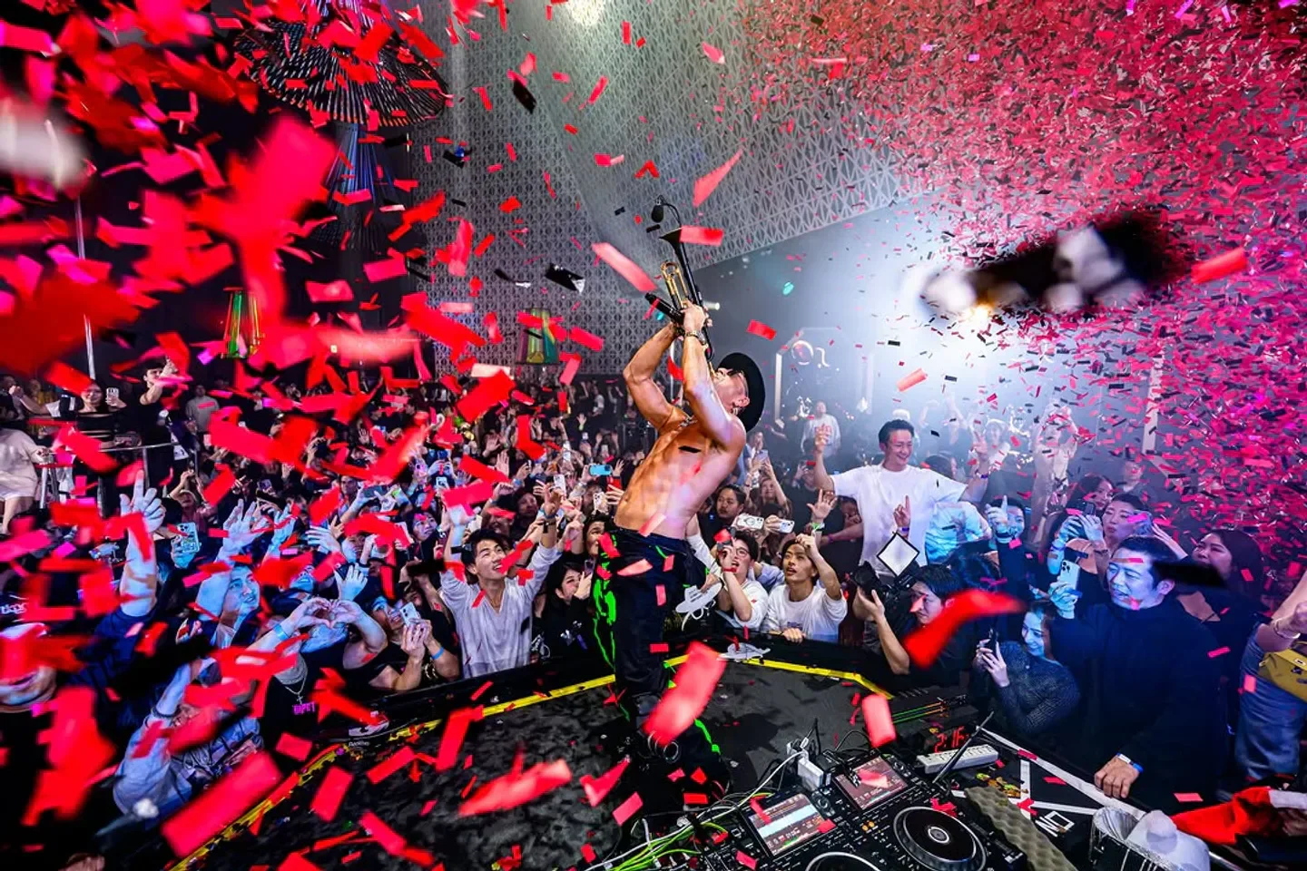 Energetic party at RAISE nightclub in Tokyo with confetti and a live musician.
