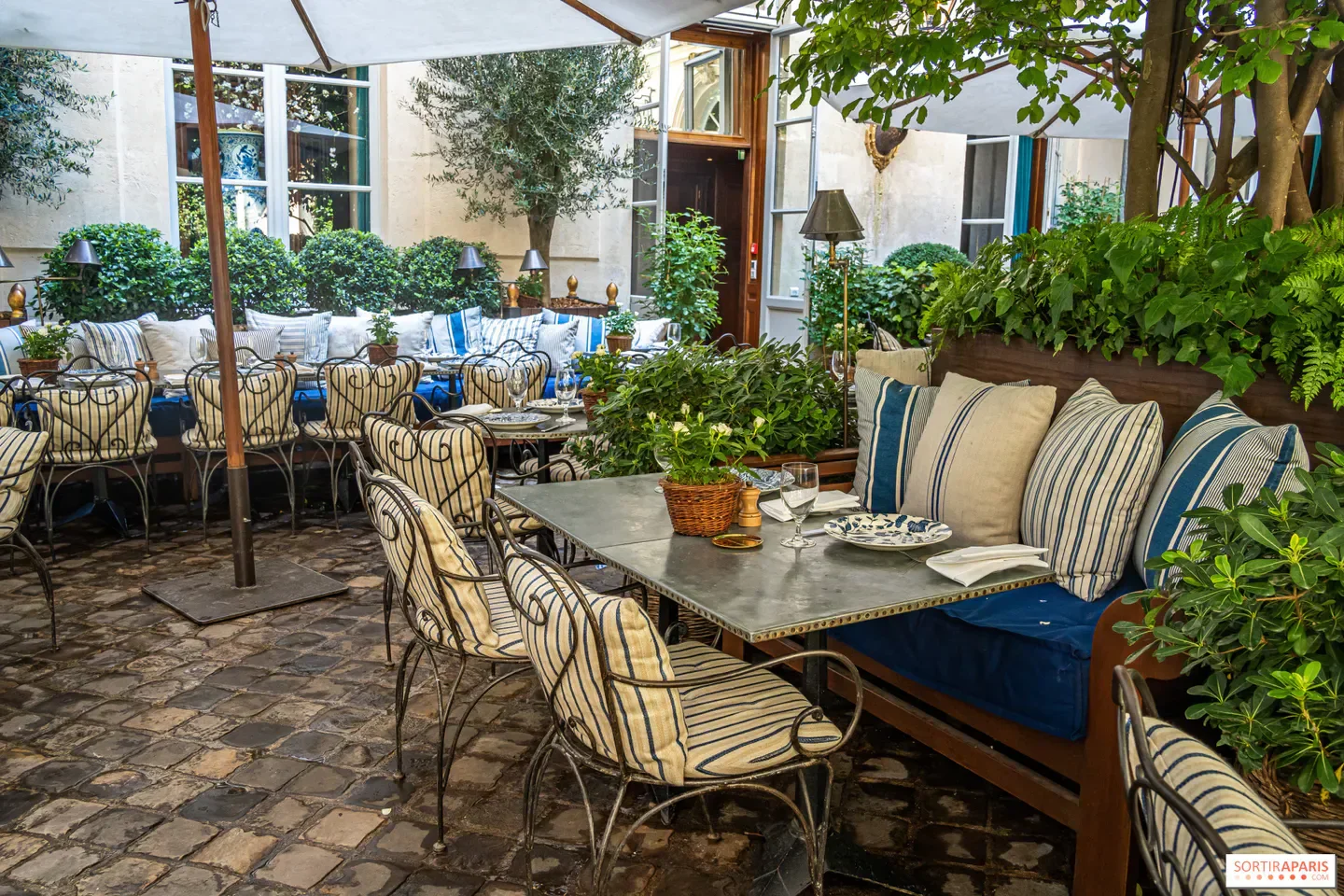 Charming outdoor dining area at Ralph’s in Paris, with stylish decor and lush greenery.