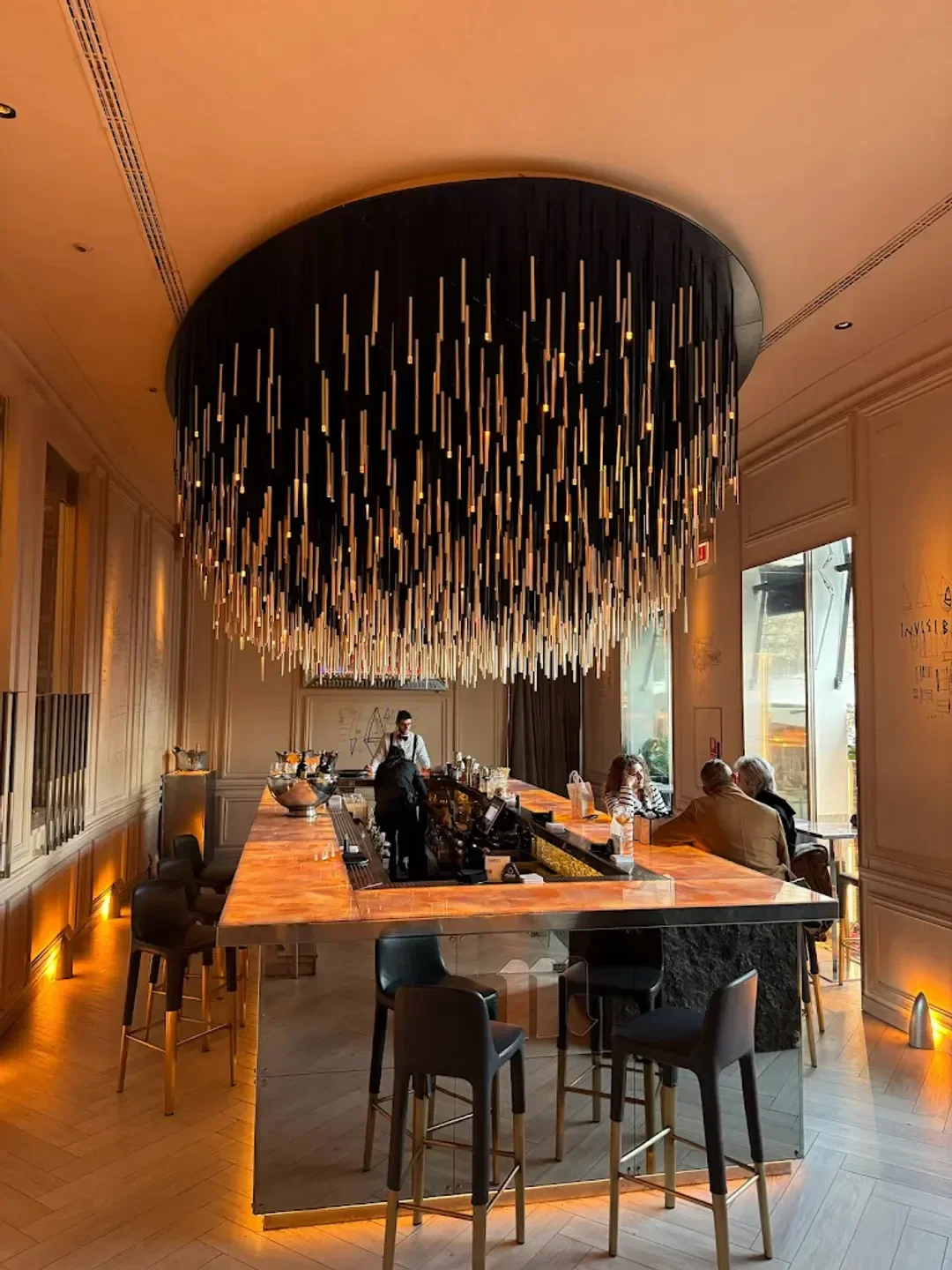 Stylish bar interior at Ramses restaurant in Madrid, featuring unique lighting and seating.