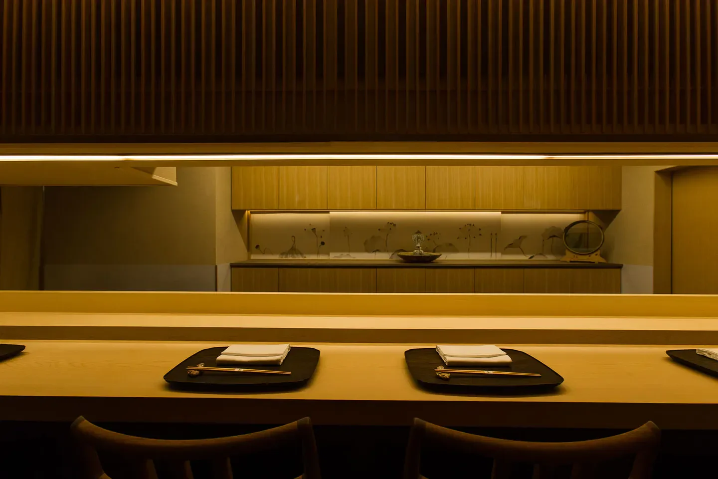 Interior of Ren Mishina restaurant in Tokyo, featuring sushi bar and wooden decor.