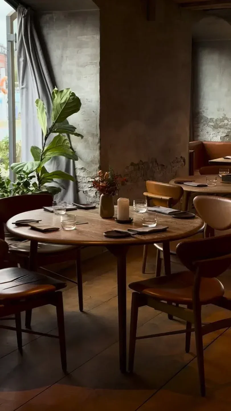 Cozy dining area at Restaurant Barr in Copenhagen, featuring wooden tables and chairs.