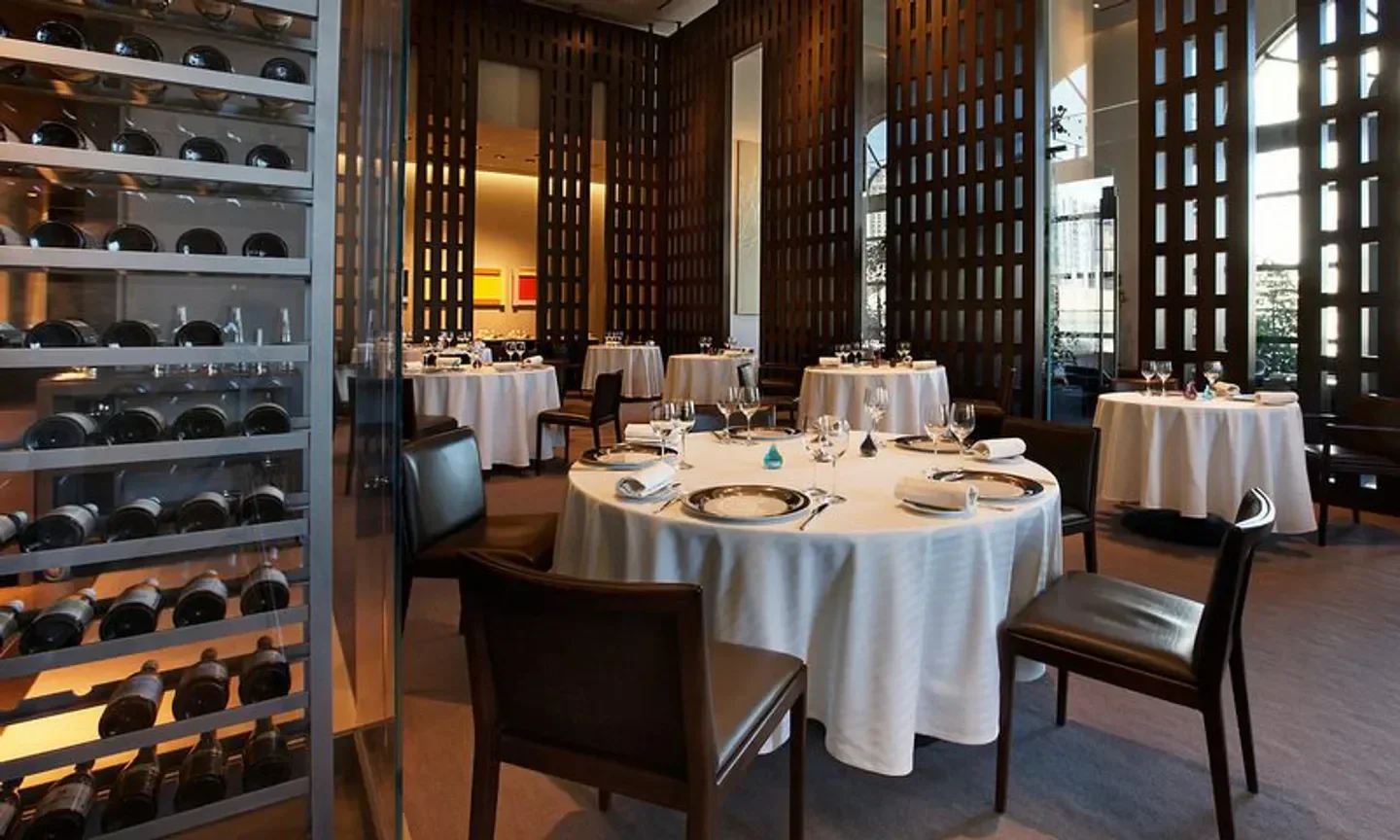 Restaurant Guy Savoy in Las Vegas: elegant dining room with round tables and wine display.