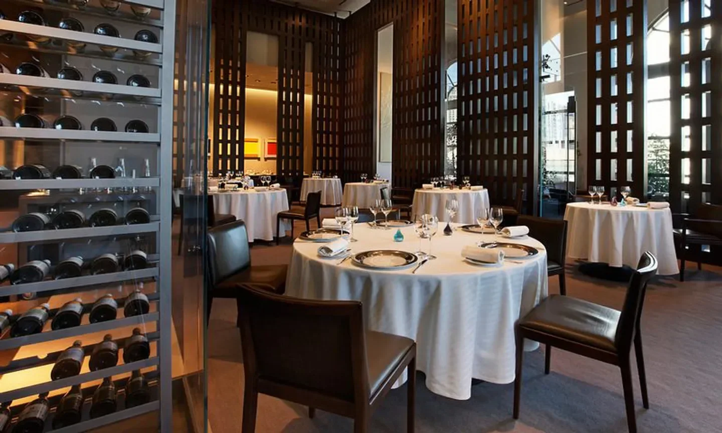 Restaurant Guy Savoy in Las Vegas: elegant dining room with round tables and wine display.
