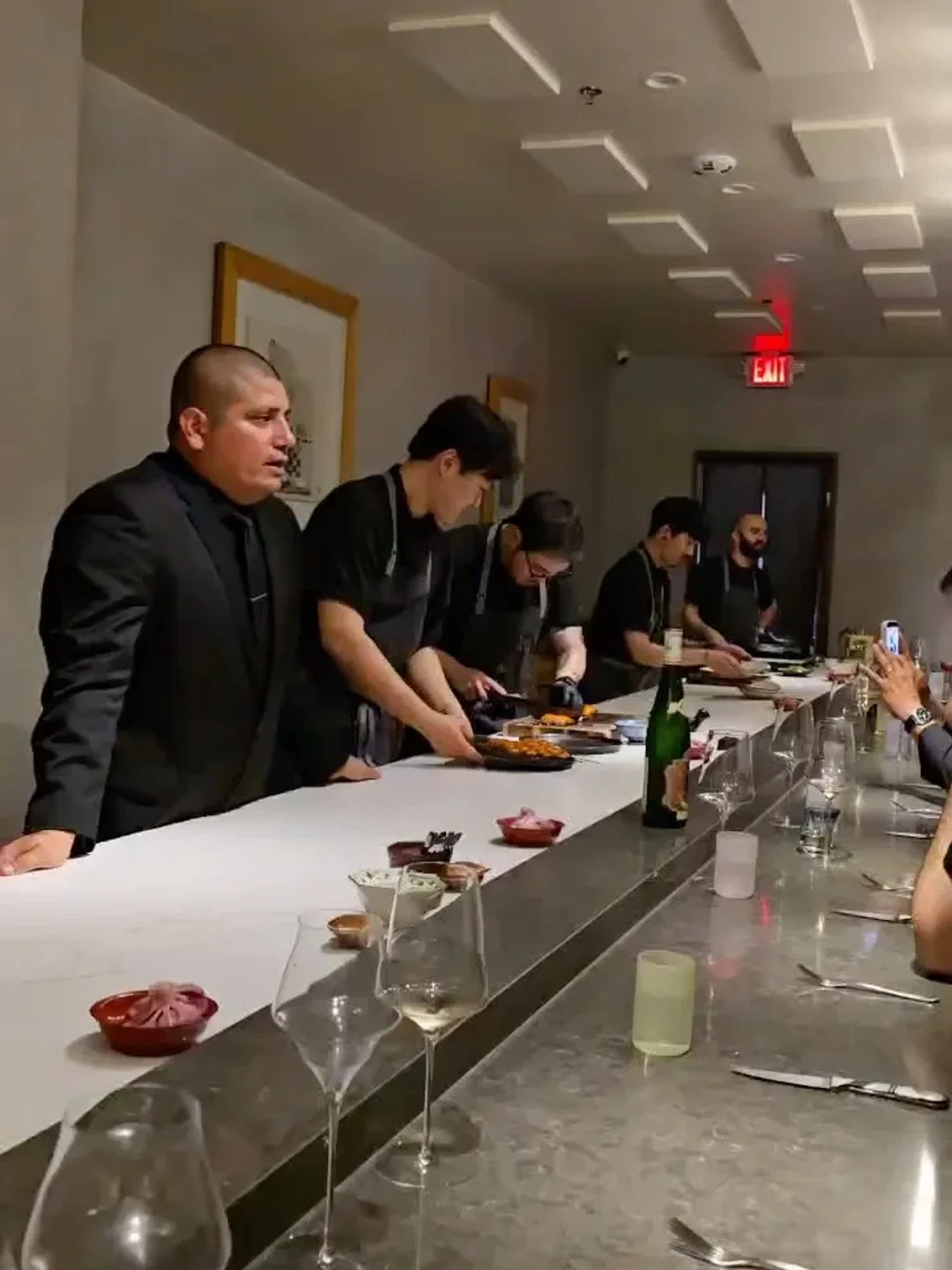 Chefs prepare food at the counter in Restaurant Ki, a modern dining spot in the city.