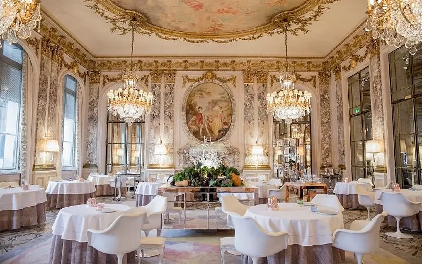 Elegant dining room at Restaurant Le Meurice Alain Ducasse in Paris, with chandeliers and tables.