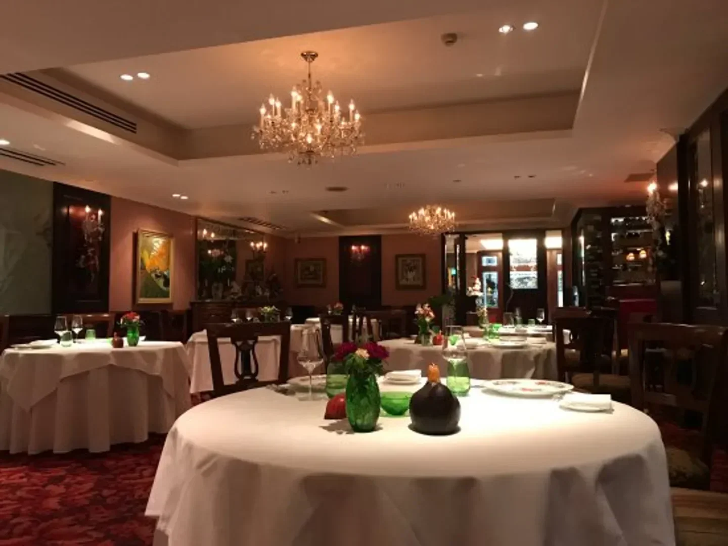 Elegant interior of Restaurant Pachon in Tokyo, featuring round tables and chandeliers.