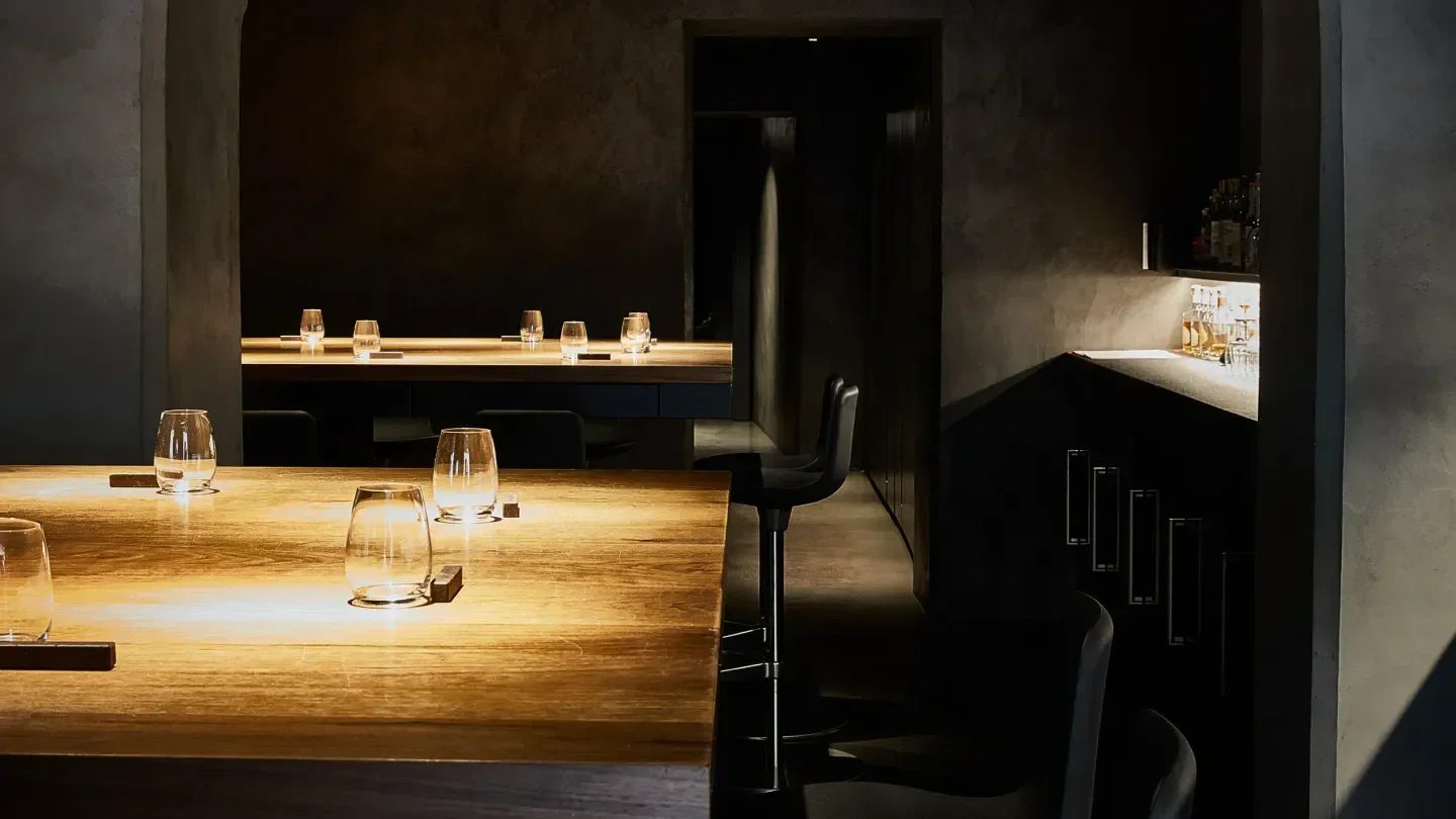 Interior of Retrobottega restaurant in Rome, showcasing elegant wooden tables and dimly lit ambiance.