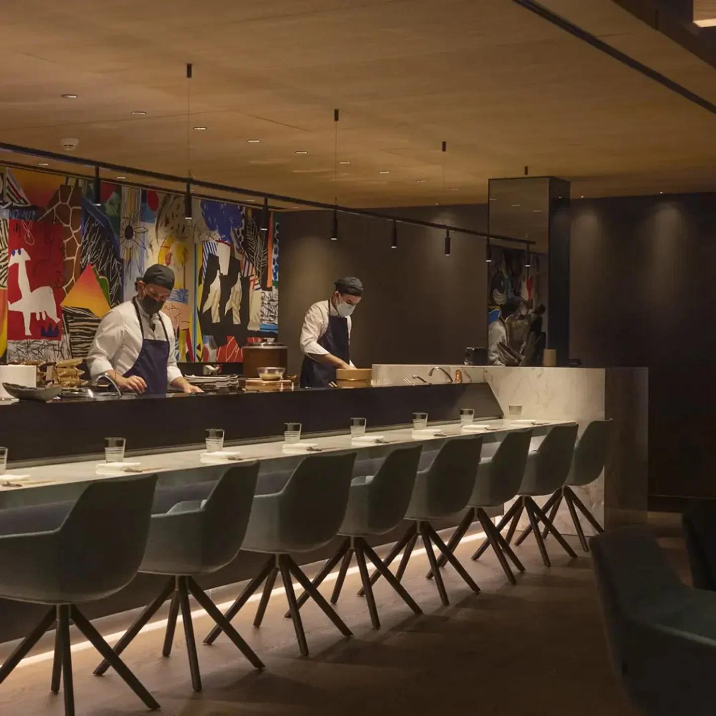 Chefs preparing food at Ricardo Sanz Wellington restaurant in Madrid's elegant dining area.