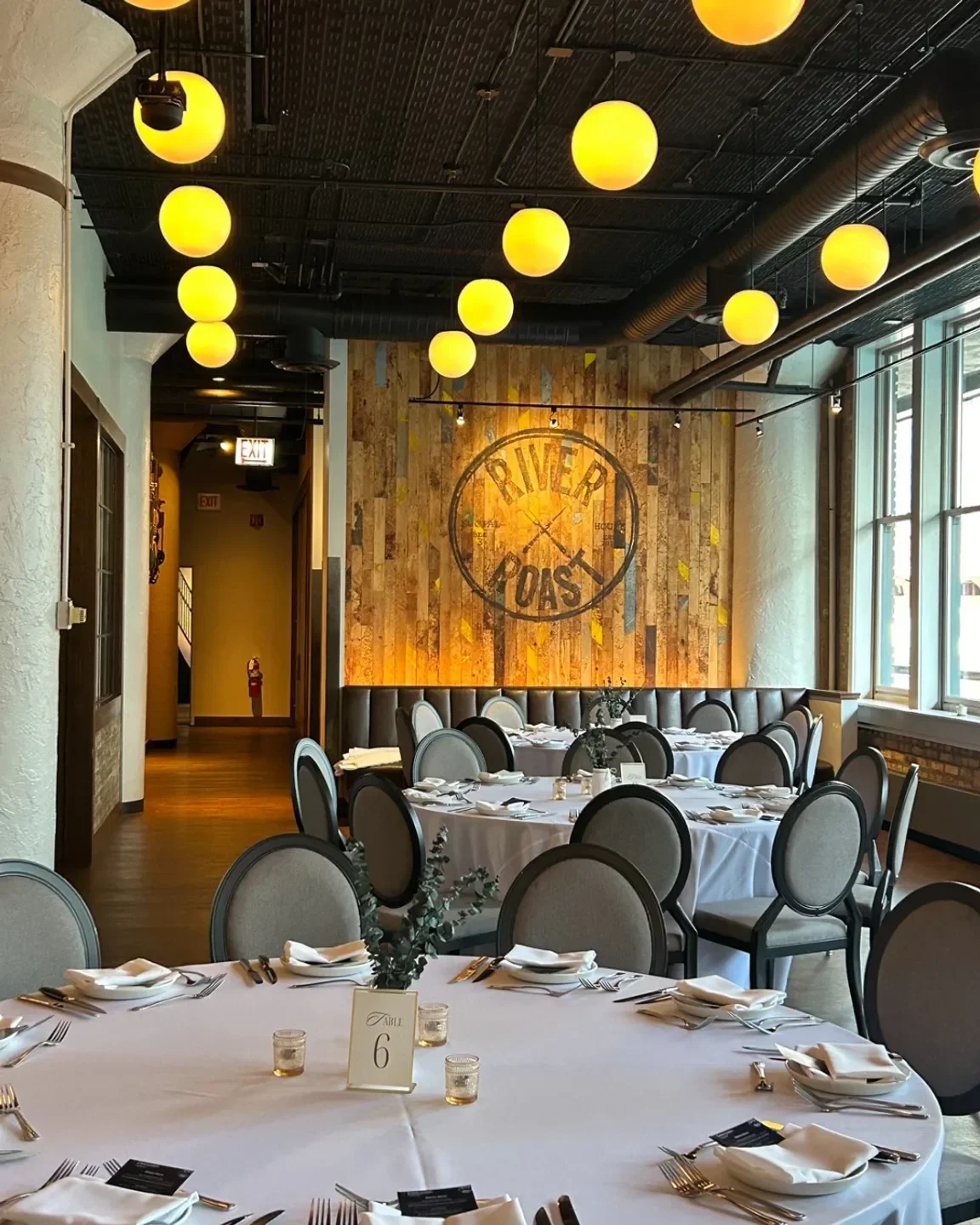 Elegant dining room at River Roast in Chicago, with round tables set for guests.