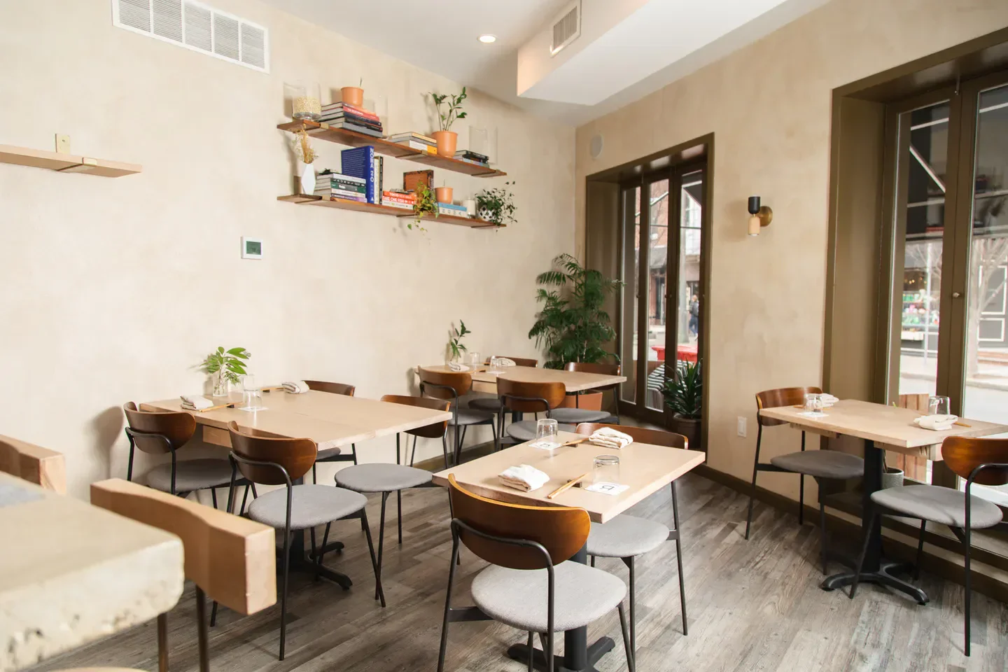 Interior of River Twice restaurant in Philadelphia with tables and bookshelves.
