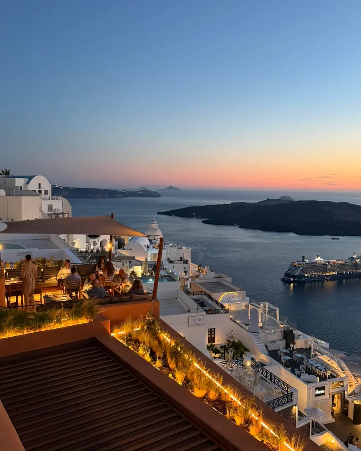 Rizes Gastro Taverna dining terrace with caldera view at dusk in Santorini, Greece.