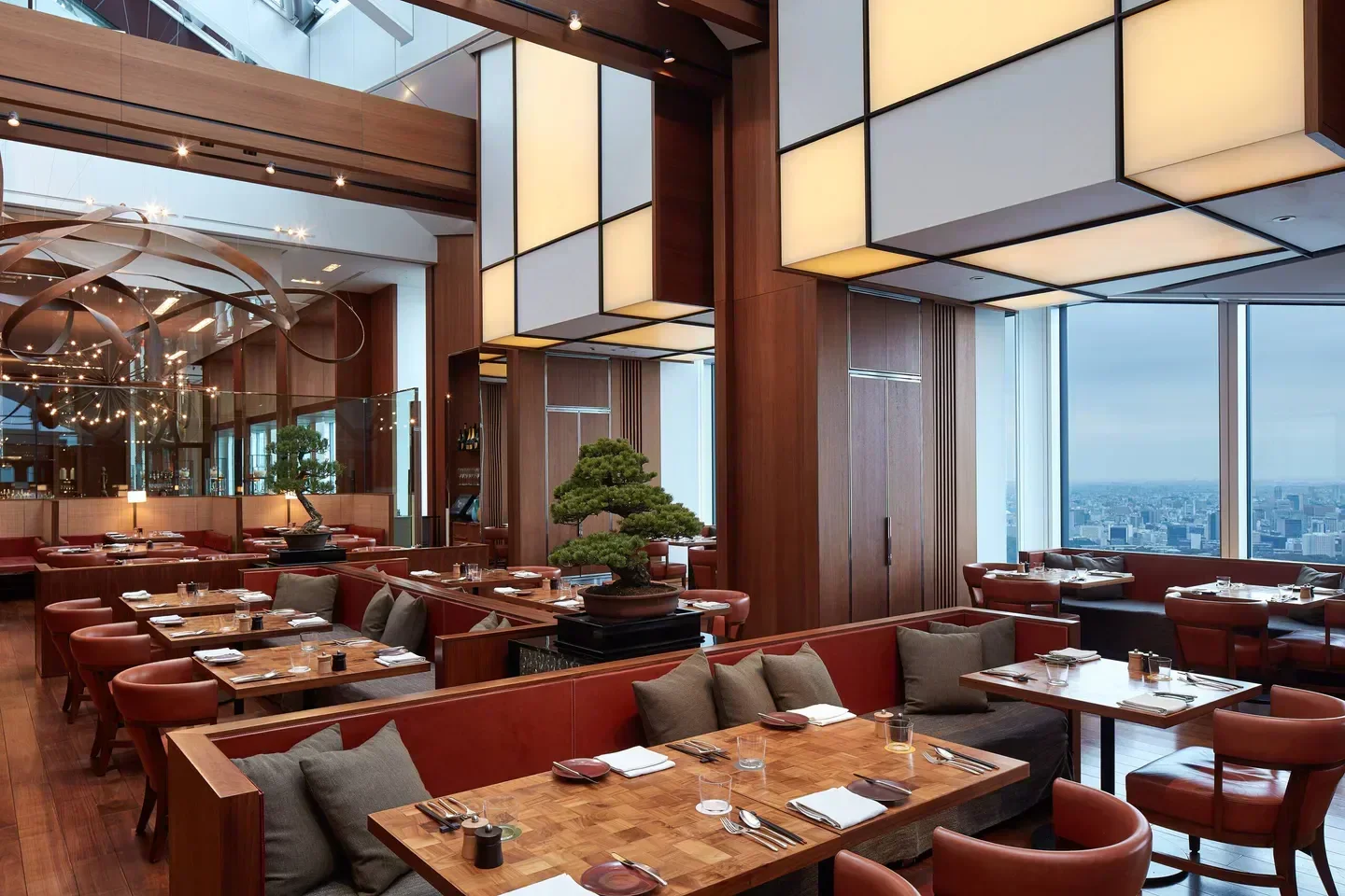 Interior of Rooftop Bar Andaz in Tokyo featuring bonsai trees and city views.