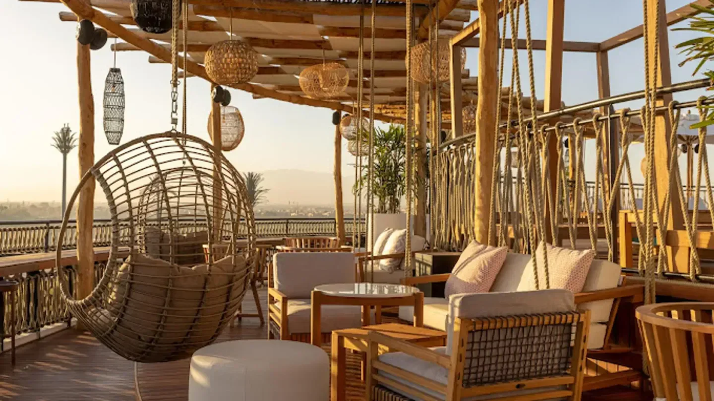 Rooftop Garden in Marrakech with swing chairs, stylish seating and city views.