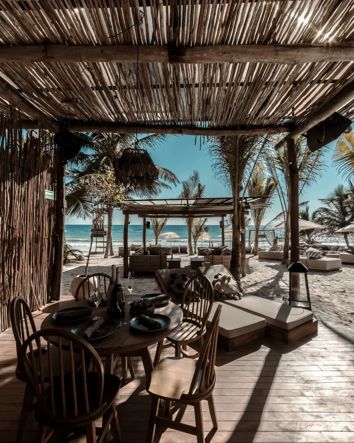 Beachfront dining at Rosa Negra in Tulum, with views of the ocean and palm trees.
