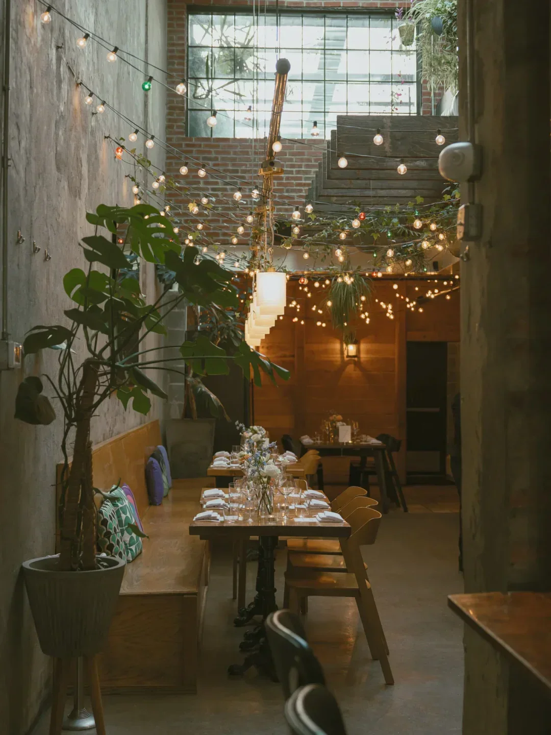Cozy dining area at Rose's Luxury in Washington, decorated with string lights.