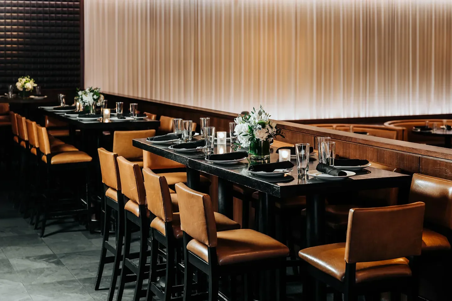 Stylish interior of RPM Steak Chicago, with tables set for service and floral arrangements.
