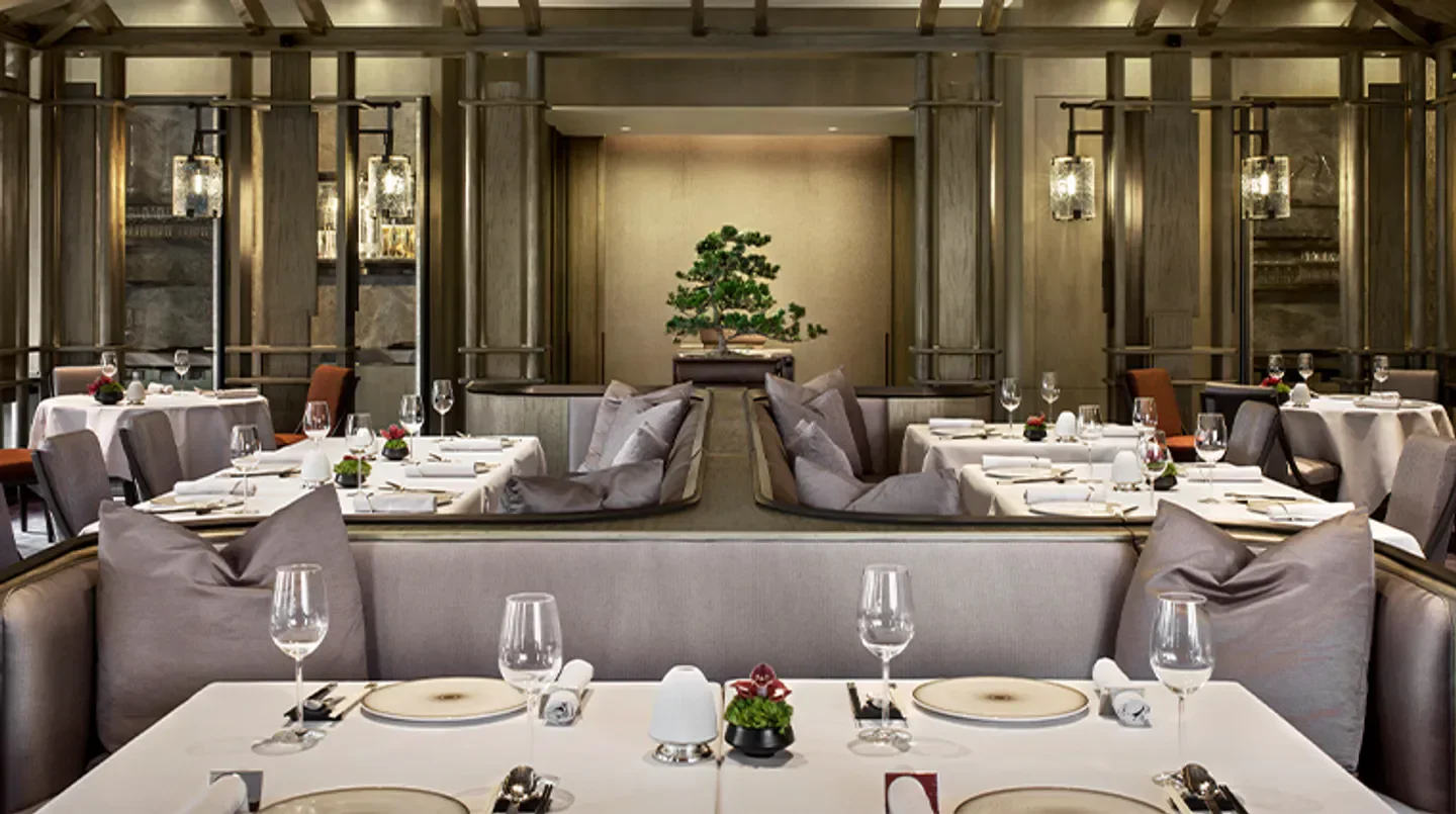 Elegant dining interior at RÙN restaurant in Hong Kong, featuring tables, cushions and decor