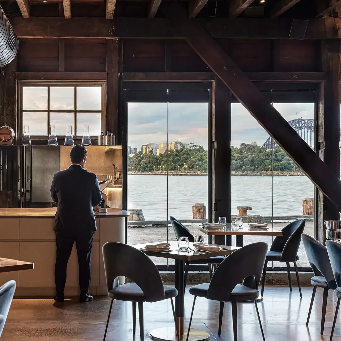 SALA Sydney restaurant interior with water views and Harbour Bridge visible.