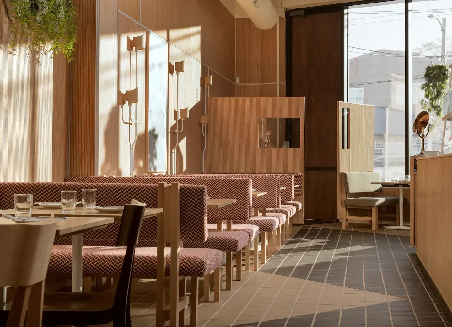 Interior dining space at Savio Volpe in Vancouver, featuring warm wood accents and booths.