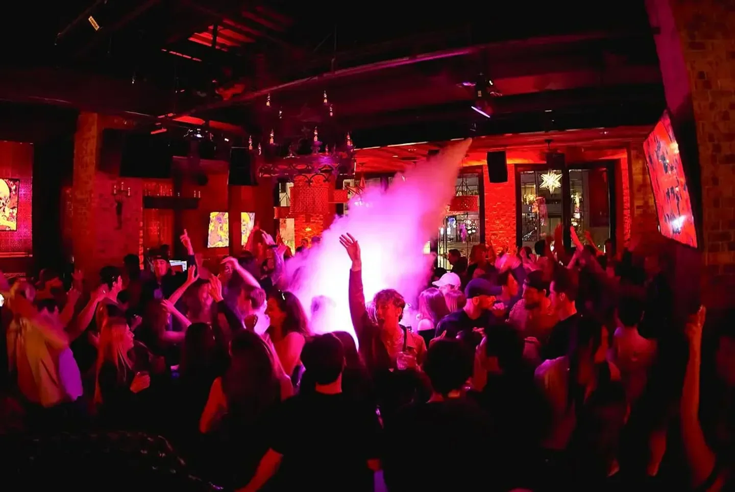 Energetic crowd partying at Scorpion Bar Boston with lights and smoke